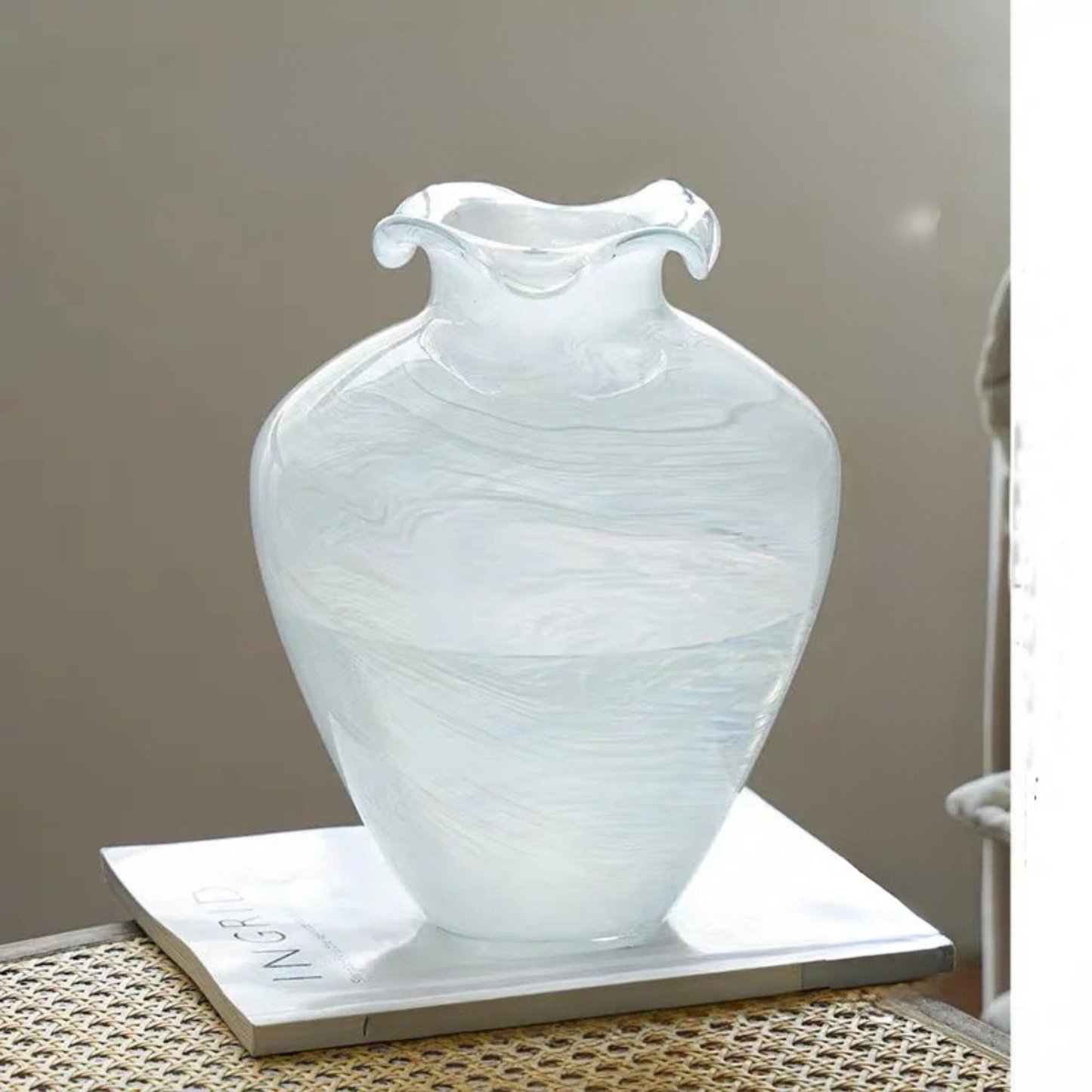 "Petal Wave" handblown glass vase in Cloud Drift — large amphora silhouette with dramatic wave rim, white swirl glass, styled on marble tray with neutral background