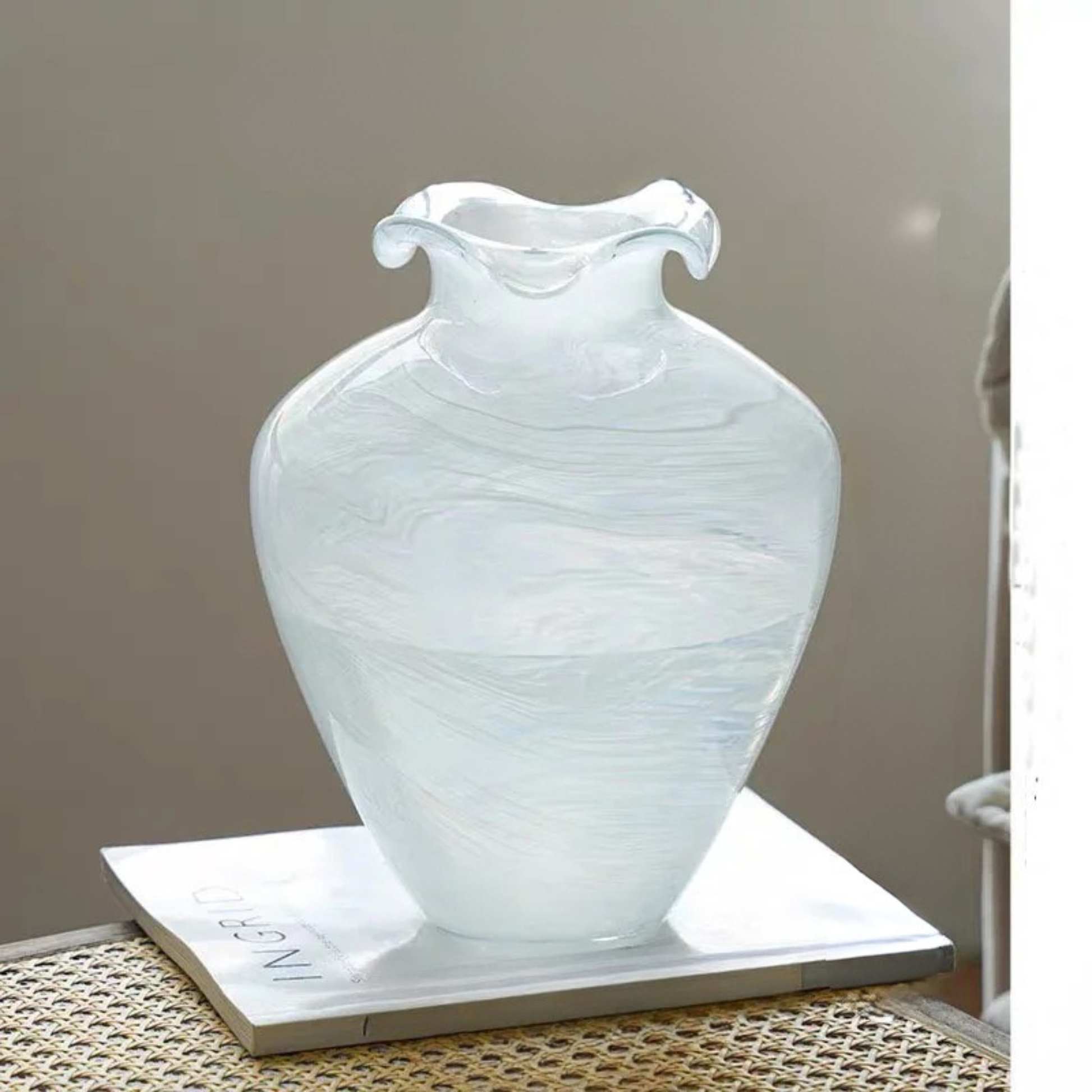"Petal Wave" handblown glass vase in Cloud Drift — large amphora silhouette with dramatic wave rim, white swirl glass, styled on marble tray with neutral background