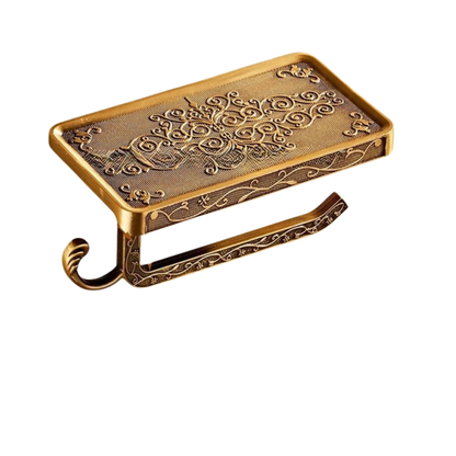 Wall-mounted antique gold toilet paper holder with ornate engraved arabesque pattern and integrated phone shelf, white background
