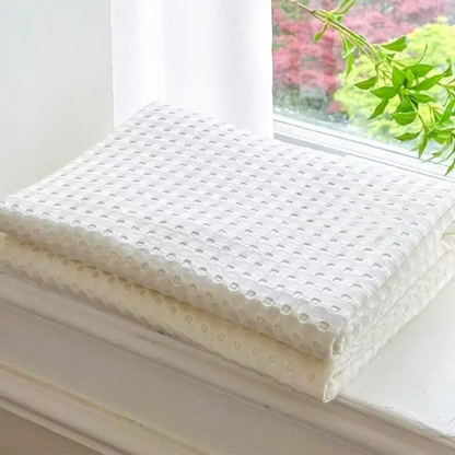"100% Bamboo Fibre waffle-texture cooling blanket in Ivory White — neatly folded on a white windowsill with natural light, soft and breathable summer bedding"