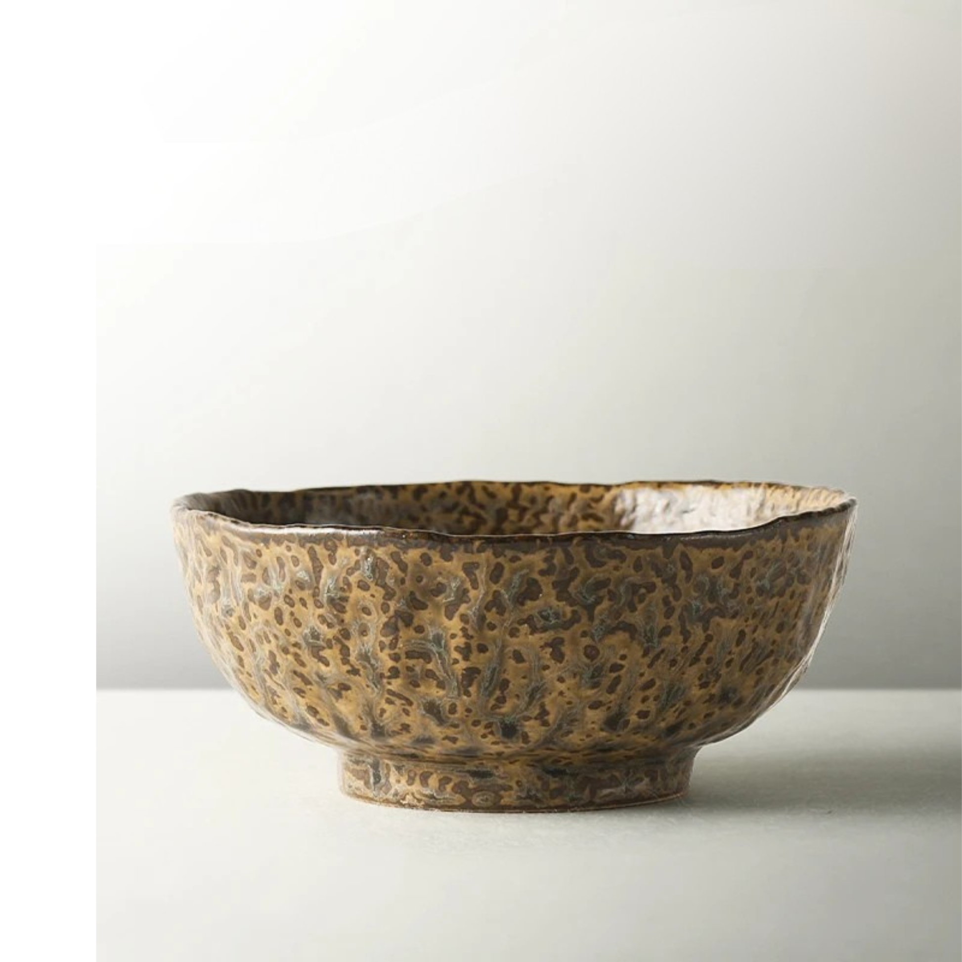 "Wabi Crest" stoneware ramen bowl in warm earth brown with speckled reactive glaze and organic irregular rim — side view on white background