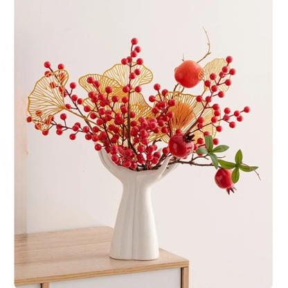  Open Hands white ceramic vase styled with red berries, pomegranates and golden ginkgo leaves on wooden shelf