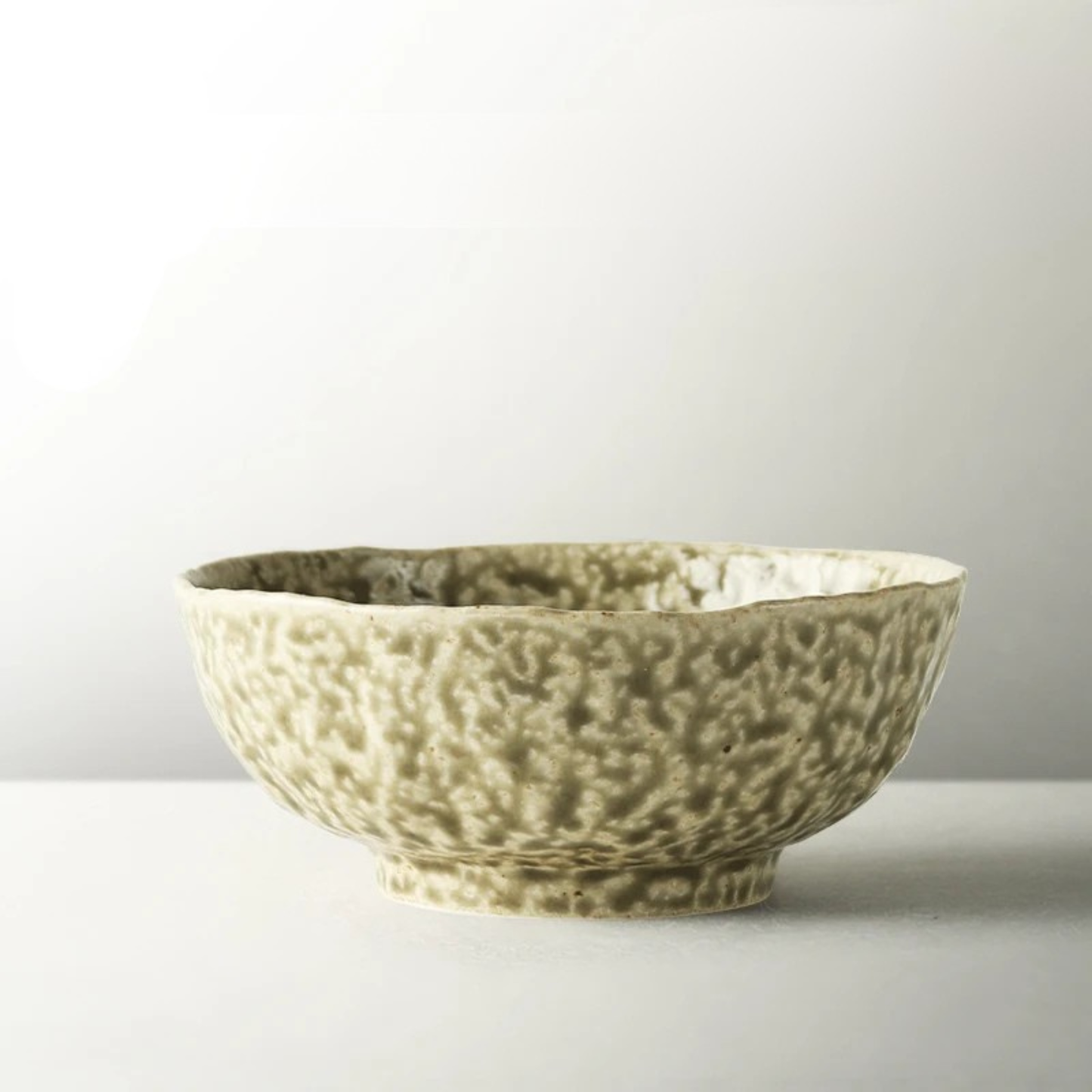 Imagem 3: "Wabi Crest" stoneware ramen bowl in natural stone cream with speckled reactive glaze and organic irregular rim — side view on white background